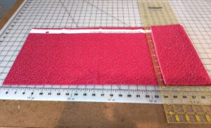 how to start folding fabric around a ruler.