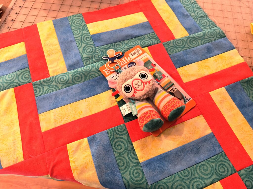 rail fence baby quilt with llama toy