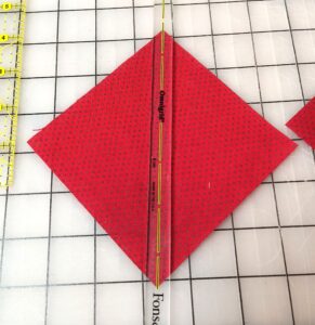 ruler on red square of fabric, corner to corner